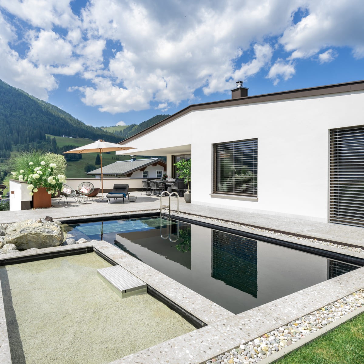 Modernes Haus mit Terrasse und Pool in einer malerischen Berglandschaft